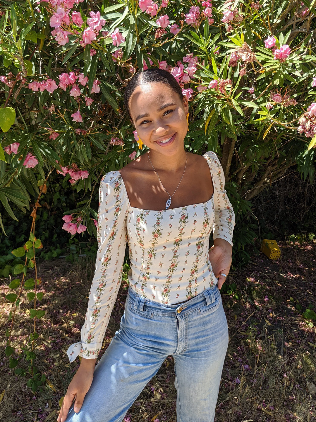 Mikaela is wearing the Ariana Top in POPPYSEED.